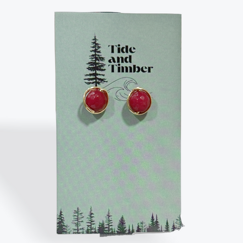 Red earrings on a Tide and Timber branded card with a white background
