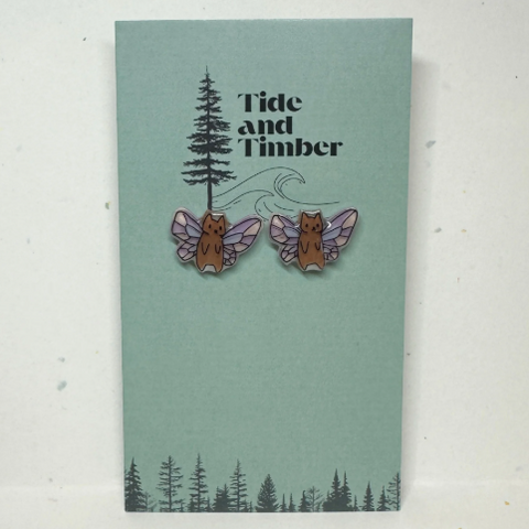 Earrings with animal designs on a card labeled 'Tide and Timber' against a light gray background.