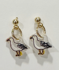 Pair of seagull-shaped earrings on a light gray background