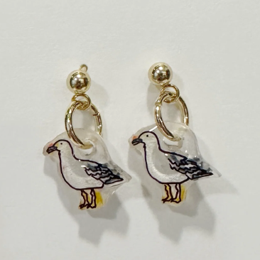 Pair of seagull-shaped earrings on a light gray background