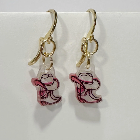 Cowboy boot earrings with gold hooks on a light gray background