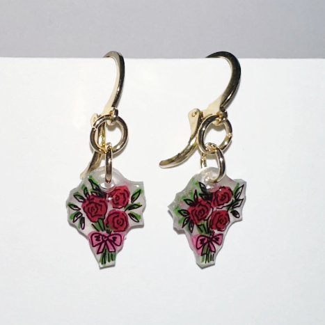 Pair of earrings with floral designs on a white background
