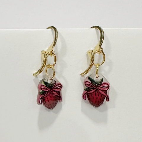 Handmade earrings with strawberry design on a white background