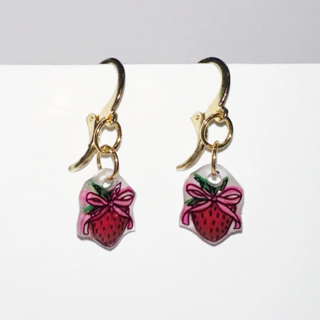 Handmade earrings with strawberry design on a white background