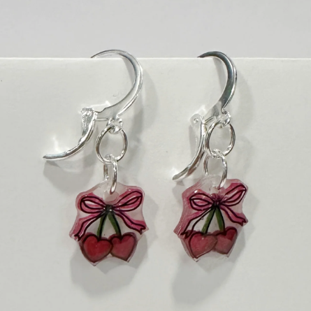 Pair of earrings with berry design on a white background
