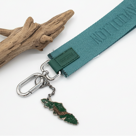 Green keychain with a small green tag on a wooden surface