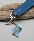 Blue keychain with a map design on a wooden surface