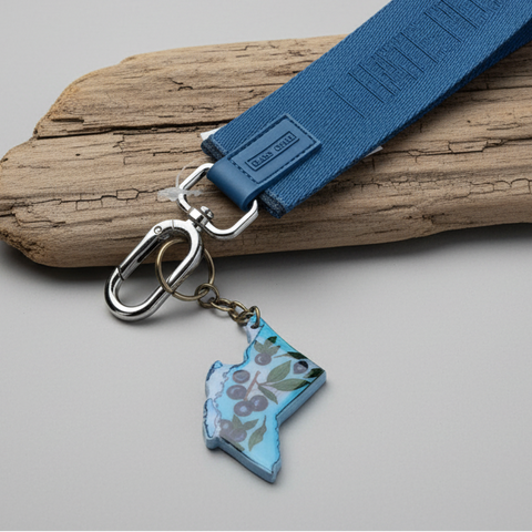 Blue keychain with a map design on a wooden surface