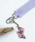 Keychain with floral state-shaped charm on a wooden surface