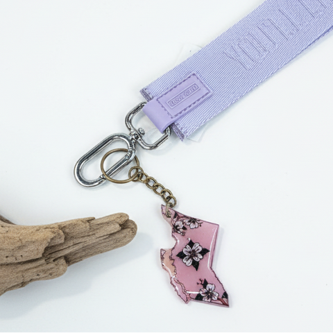 Keychain with floral state-shaped charm on a wooden surface