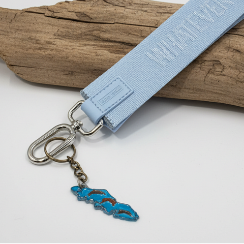 Light blue lanyard with a keychain on a wooden surface