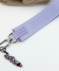 Lavender keychain strap with a small charm on a wooden surface