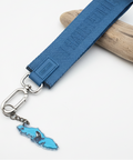 Blue keychain with a map charm on a wooden surface
