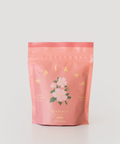 Pink packaging with floral design and text on a light gray background