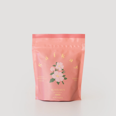 Pink packaging with floral design and text on a light gray background