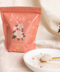Pink package with floral design labeled 'SKWALVEN' next to a bowl of rice with a spoon on a light background
