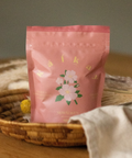 Pink packaging with floral design on a woven basket