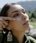 Woman with a hand touching her hair against a natural background