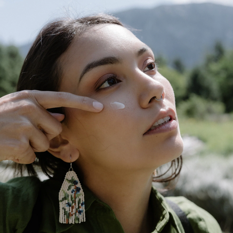 Woman with a hand touching her hair against a natural background