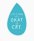 Teal teardrop-shaped sticker with white text 'Life is hard. It's okay to cry.' on a white background