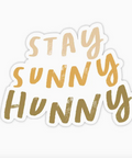 Sticker with 'Stay Sunny Hunny' text in gold on a white background