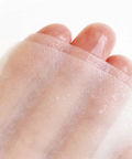 Close-up of a foot with a transparent patch on a white background