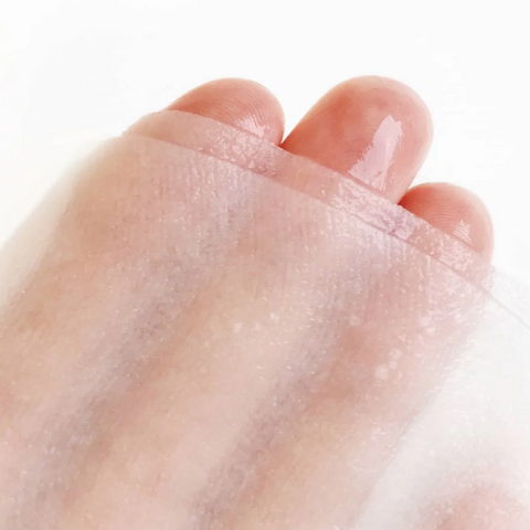 Close-up of a foot with a transparent patch on a white background