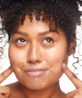 Woman with a clear sheet applied to her face against a white background