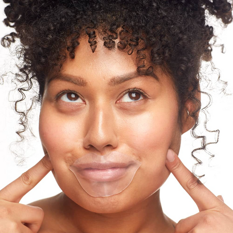 Woman with a clear sheet applied to her face against a white background