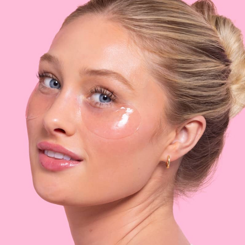 Woman with eye patches on a pink background