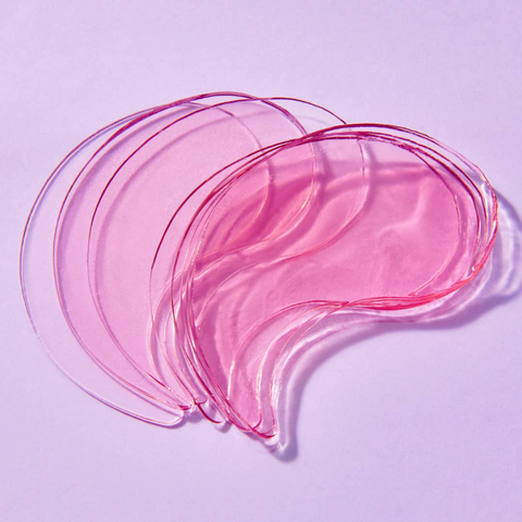 Pink and clear eye masks on a light purple background