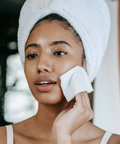 Woman applying a facial mask with a towel on her head