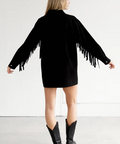 Person wearing a black fringe jacket with a white background