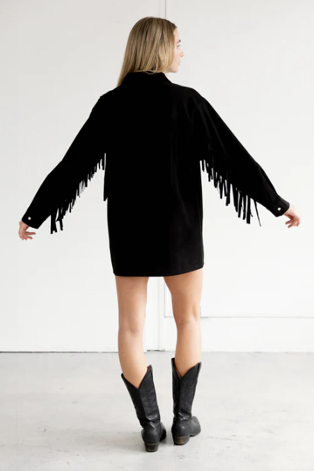 Person wearing a black fringe jacket with a white background