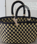 Woven basket with black and beige pattern on a wooden surface