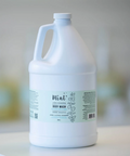 Large white bottle of Mint body wash on a light surface with a blurred background