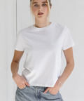 Person wearing a plain white t-shirt and light blue jeans against a white background