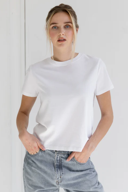 Person wearing a plain white t-shirt and light blue jeans against a white background