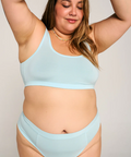 Woman wearing a light blue bikini set against a plain background