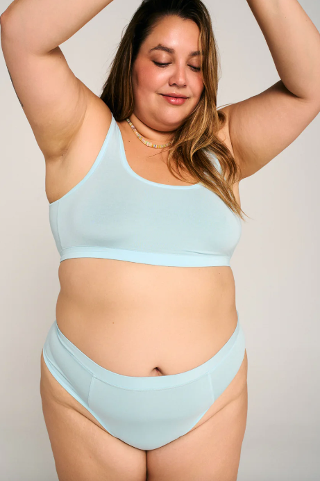 Woman wearing a light blue bikini set against a plain background
