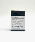 Bar of soap with packaging labeled 'Raven Song' on a white background