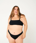 Woman wearing a black bikini set on a white background