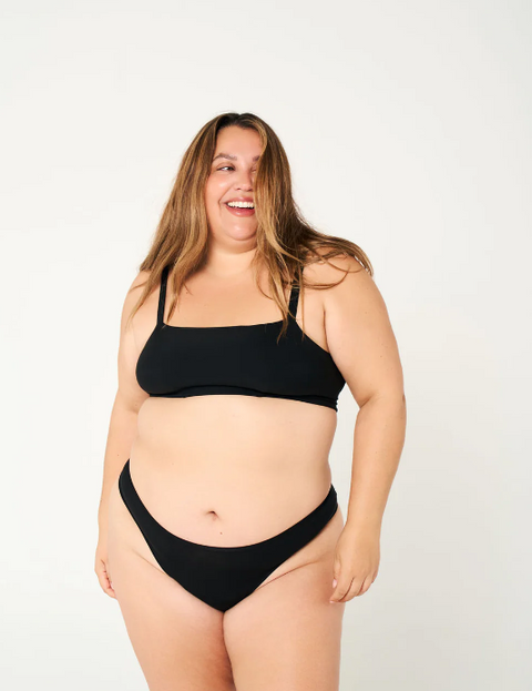 Woman wearing a black bikini set on a white background