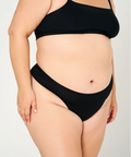 Person wearing a black bikini set on a plain background