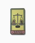 Enamel pin with 'Justice' design featuring two cats on a balance scale on a yellow background.