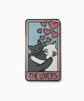 Enamel pin with two cats hugging and hearts above, labeled 'The Lovers', on a white background.