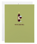 Greeting card with wine bottle and glass illustration and 'You've Aged Well' text on a green background