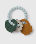 Silicone baby teether with a light blue beaded ring and three textured chewable pieces: a dark green leaf, a cream sun, and a brown lion face.