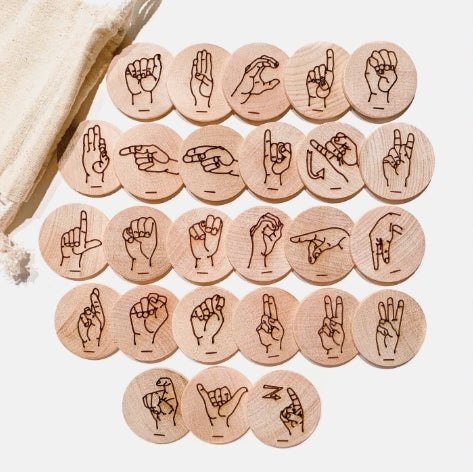Set of wooden tokens with engraved hand signs on a light background