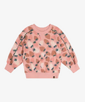 A pink long-sleeve crewneck sweatshirt featuring an all-over strawberry print in shades of brown, beige, and dark green, displayed flat against a light gray background.